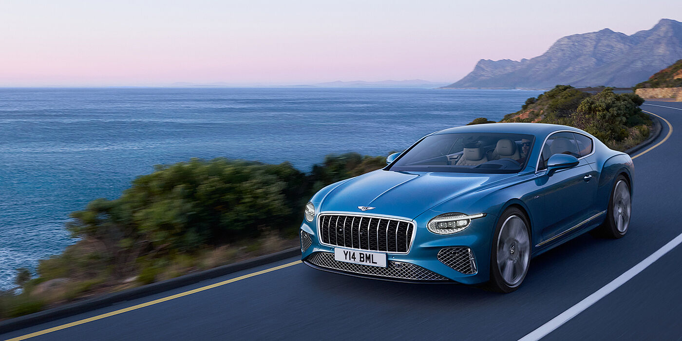 Bentley Muscat New Bentley Continental GT Azure coupe in Light Windsor blue paint with 22 inch Azure wheels and chrome grill, driving dynamically by the se