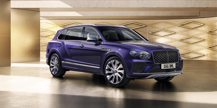 Bentley Muscat Bentley Bentayga Extended Wheelbase Mulliner SUV front three quarter in Tanzanite Purple paint with a gold patterned background