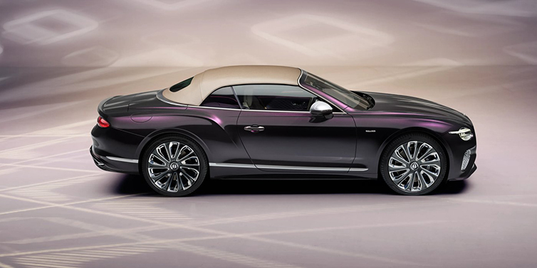 Bentley Muscat Bentley Continental GTC Mulliner convertible in profile with hood up, in Tanzanite Purple paint and 22 inch Mulliner painted and polished wheels