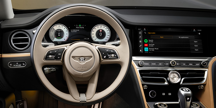 Bentley Muscat Bentley Flying Spur Mulliner sedan front interior detail of steering wheel and driver screens surrounded by Linen and Beluga black hides