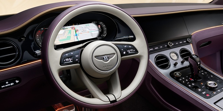 Bentley Muscat Bentley Continental GT Mulliner coupe front interior showing steering wheel and drivers screens surrounded by Linen and Damson hides and Grand Black veneer